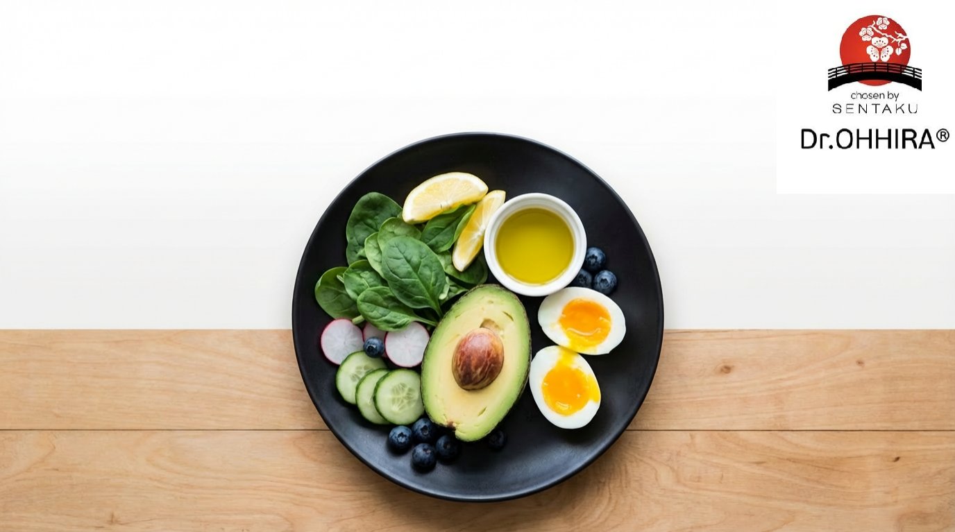 Mustal taldrikul on spinat, avokaado, muna, kurk, redis, mustikad, sidrun ja õli kauss, puidust laual.