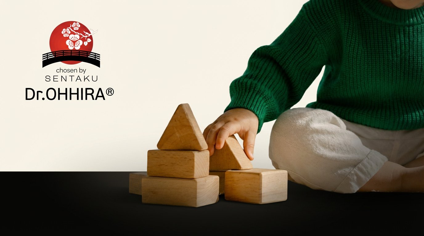 Laps rohelises kampsunis mängib puidust klotsidega, taustal Dr.OHHIRA® logo.
